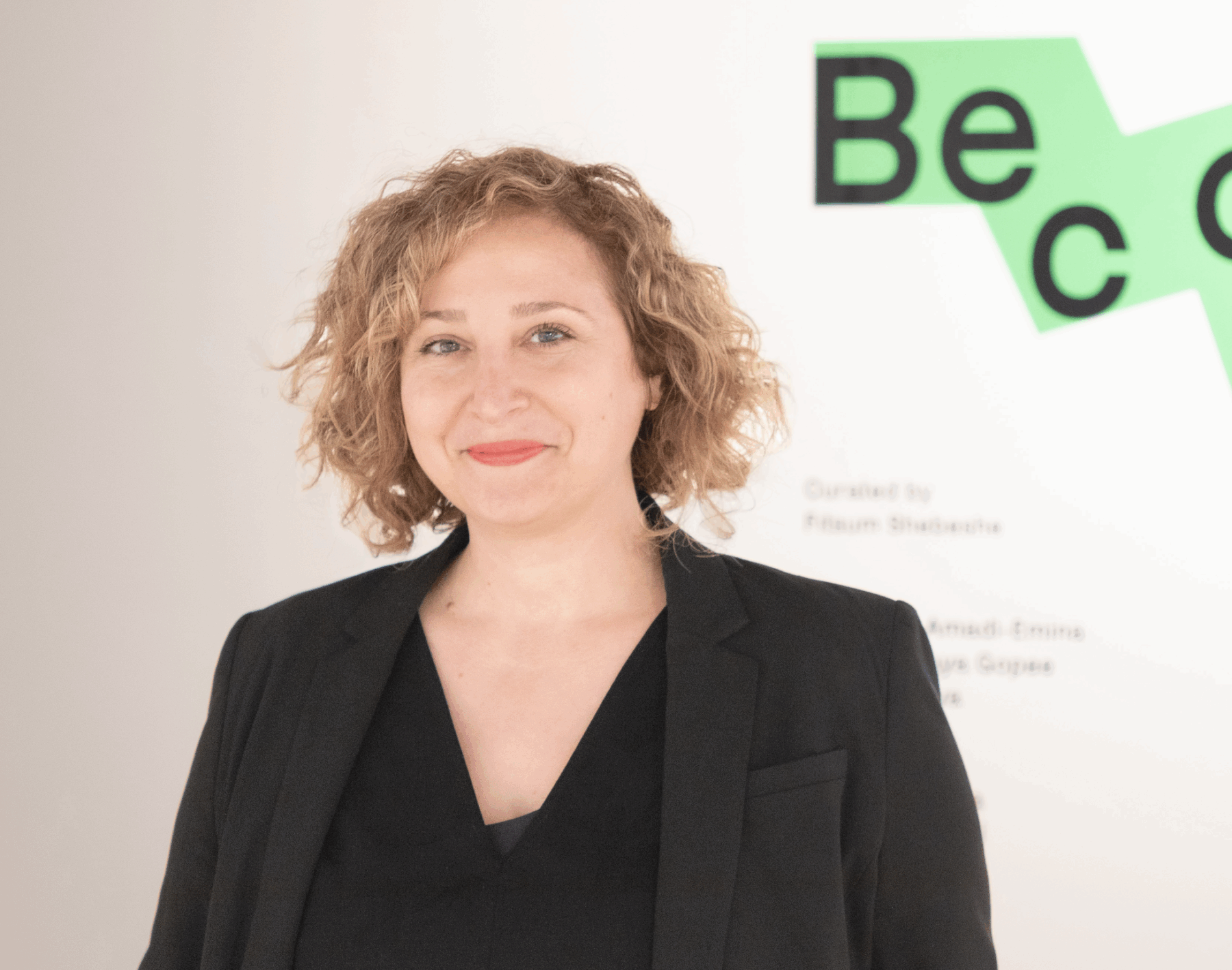 Rebecca Uchill, a woman with a light skin tone and short blonde hair. She is wearing a black blazer and is grinning for the camera.