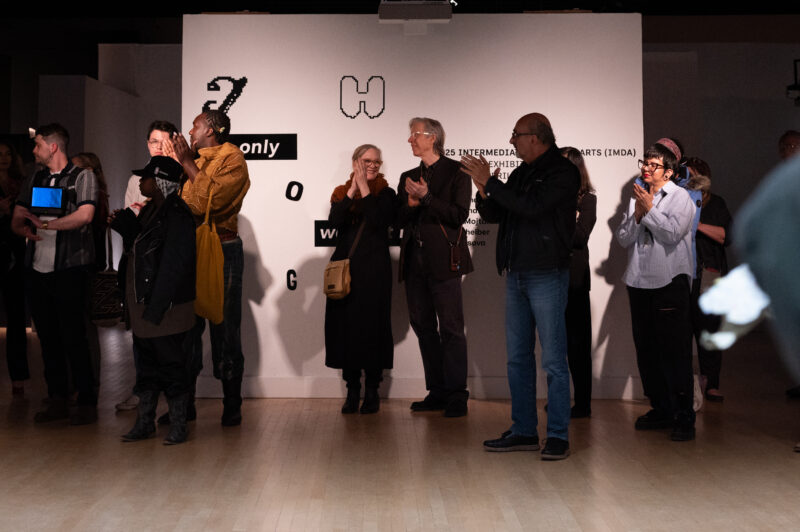 Visitors applauding artists at The Only Way Out is Through opening reception.