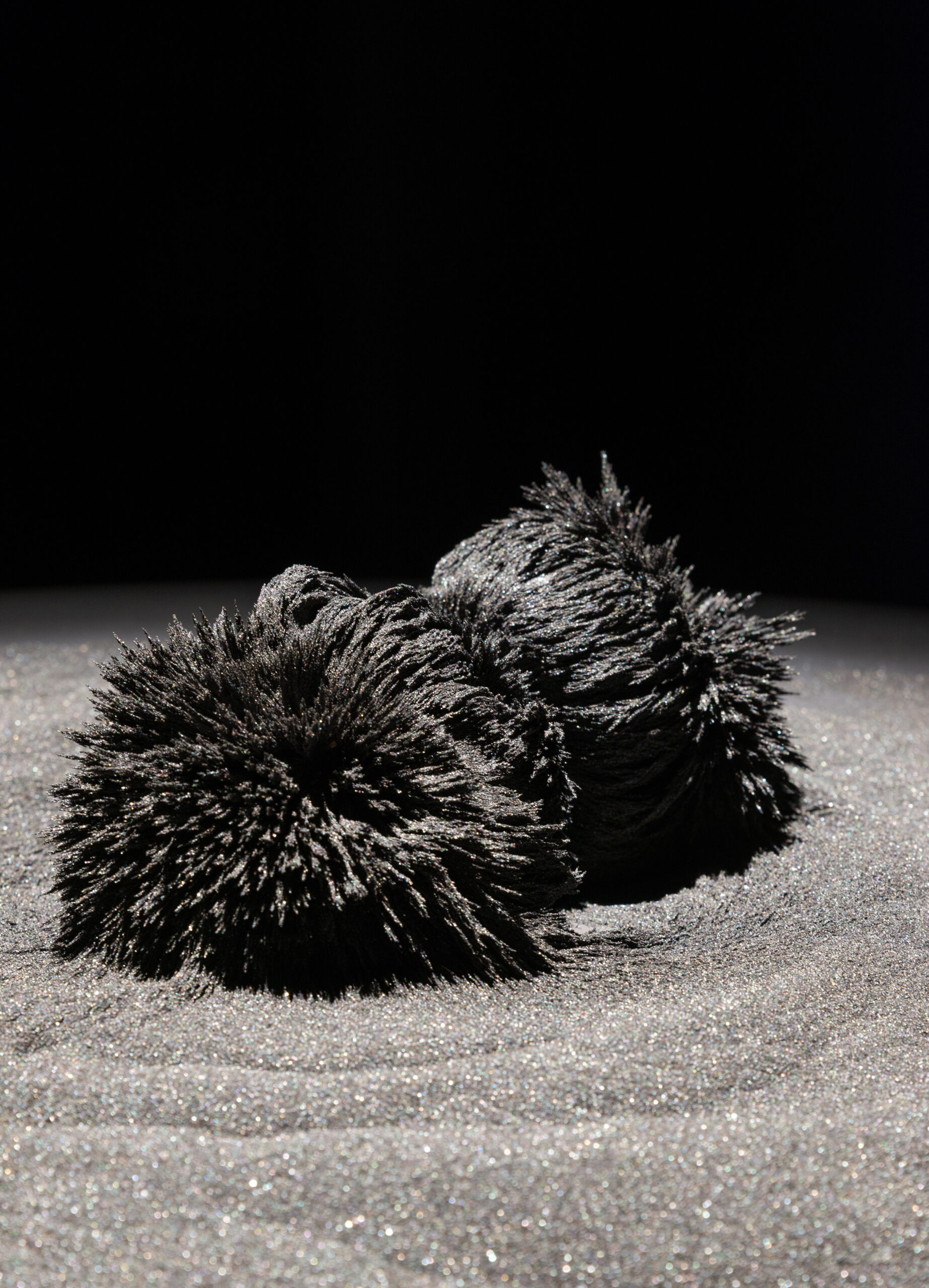 Mixed media work featured metal-spiked spheres in a bed of grey sand.