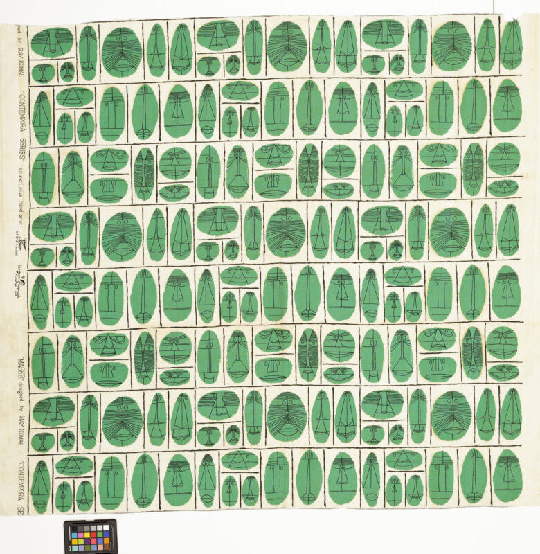 A portion of wallpaper featuring kelly green masks on a white background. They are arranged in a decorative grid pattern.