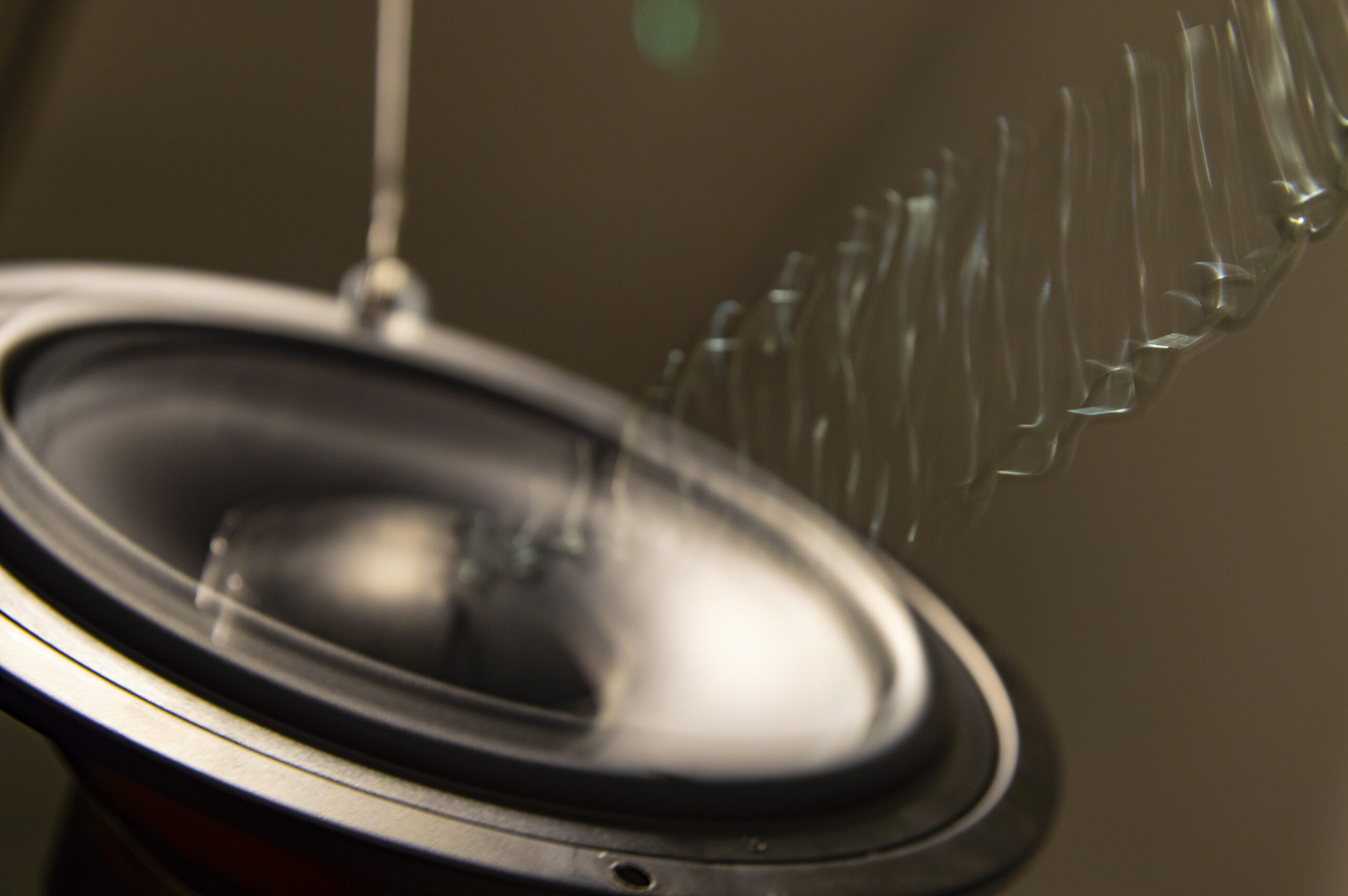 A photograph of a loudspeaker with visual sound waves emitted from it.