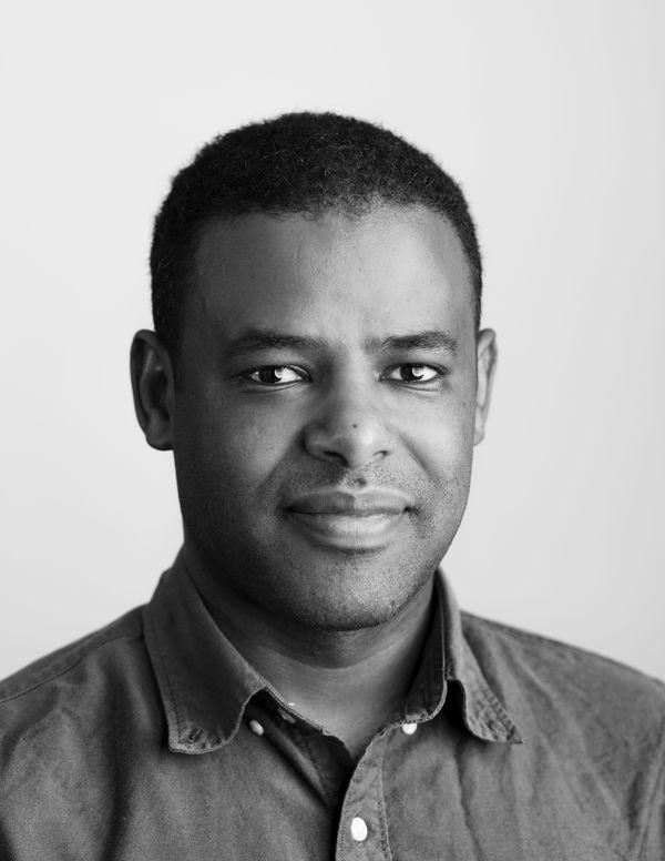A black and white portrait of a man wearing a collared shirt.