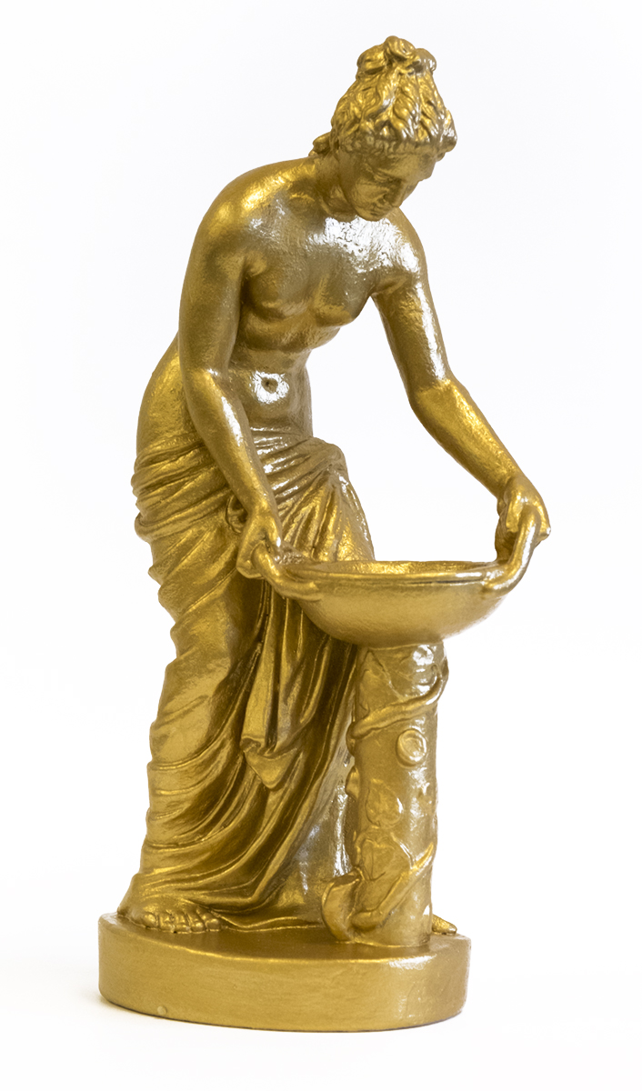 A gold-colored sculpture of a woman holding a washing basin atop a pedestal.
