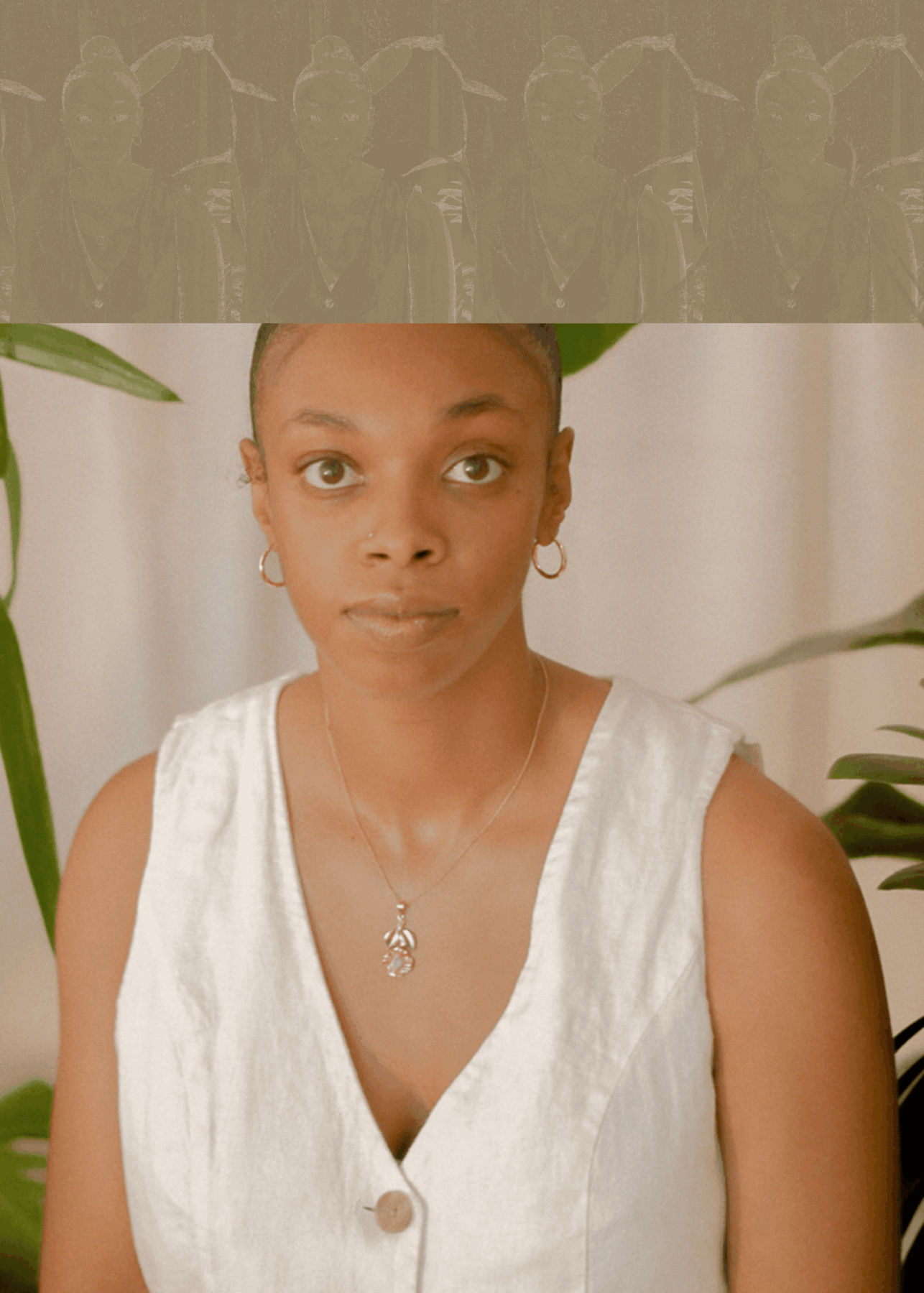 Portrait of a woman with a light brown skin tone, hair tied back in a high bun, wearing gold hoop earrings, a gold necklace, a white vest, and a nose ring, with plants in the background.